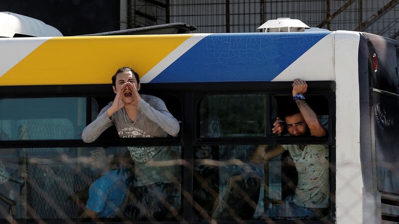 A migrant shouts to journalists from a bus window during a police operation to clear out a makeshift migrant camp at the disused Hellenikon airport in Athens, Greece, in recent days. File photograph: Costas Baltas/Reuters