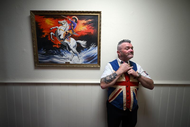 An Orangeman prepares for celebrations inside the main Orange Hall underneath a portrait of King William of Orange. Photograph: Charles McQuillan/Getty Images